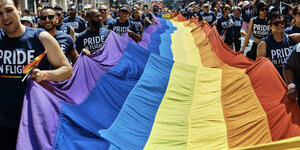 In New York protestiert die LGBTQ Szene, wir sehen die Regenbogenfahne über den gesamten Bildmittelpunkt