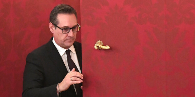 Ex-FPÖ-Chef Heinz-Christian Strache guckt hinter einer Tür hervor