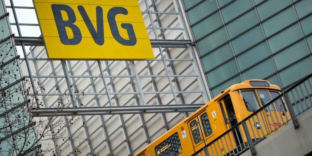 Gelbe U-Bahn fährt unter BVG-Schild
