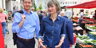 Eine Frau und ein Mann stehen auf einem Marktplatz