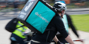 Ein Fahrer mit einer Deliveroo-Auslieferungsbox, aufgenommen bei einer Kundgebung gegen schlechte Arbeitsbedingungen beim Essenslieferdienst Deliveroo.