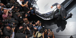 Mercedes-Boss Dieter Zetsche kniet neben einem Mercedes auf der IAA