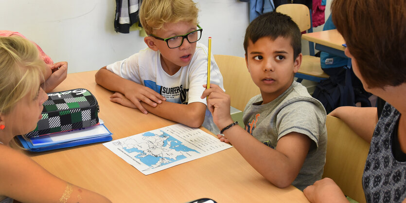 Drei Schüler bekommen Unterstützung von ihrer Lehrerin