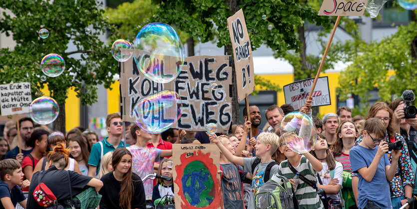 Demonstranten mit Plakaten und Seifenblasen