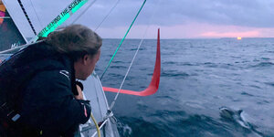 Greta Thunberg beobachtet vom Segelschiff aus einen Delfin