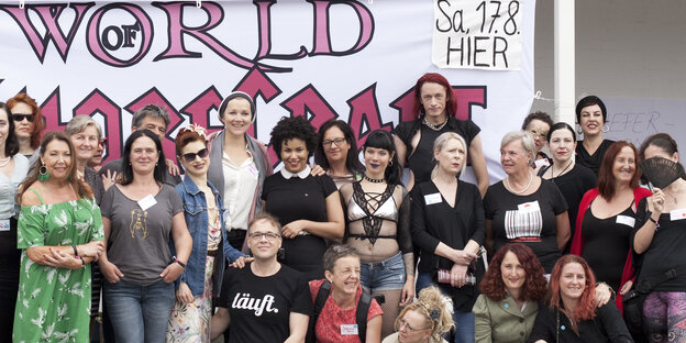 Menschen posieren vor einem Banner mit der Aufschrift "World of Whorecraft" Menschen posieren vor einem Banner mit der Aufschrift "World of Whorecraft"