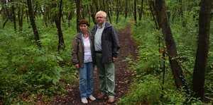 Ein Mann und eine Frau auf einem Trampelpfad im Wald