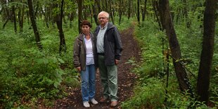 Ein Mann und eine Frau auf einem Trampelpfad im Wald