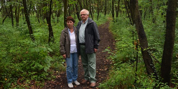 Ein Mann und eine Frau auf einem Trampelpfad im Wald Ein Mann und eine Frau auf einem Trampelpfad im Wald