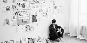 Autorin Karen Köhler lehnt an einer Wand voller Notizen
