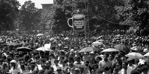 Massen an Menschen stehen vor einem Schild, auf dem "Harlem Cultural Festival" steht