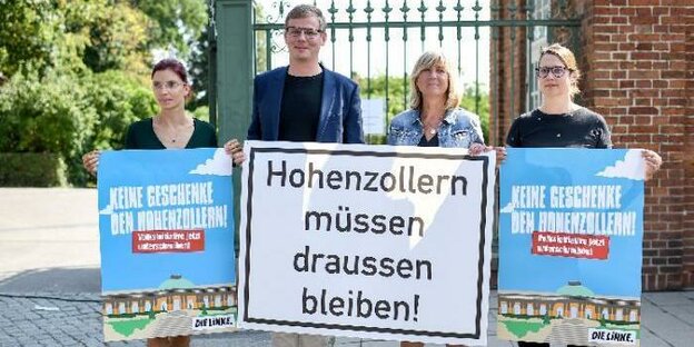Vier Menschen stehen nebeneinander, drei Frauen und ein Mann, sie halten Schilder, auf dem größten steht: Hohenzollern müssen draußen bleiben