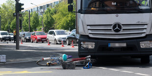 Ein Fahrrad liegt vor einem Lkw an einer Kreuzung.