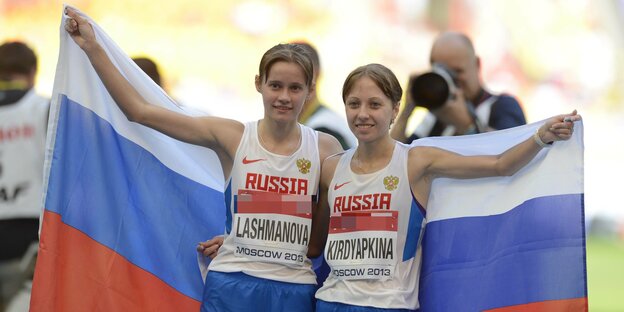 Zwei Frauen halten eine russische Flagge in ihrem Rücken hoch