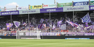 Die Fans von Osnabrück schwenken ihre Fahnen in der Fankurve.