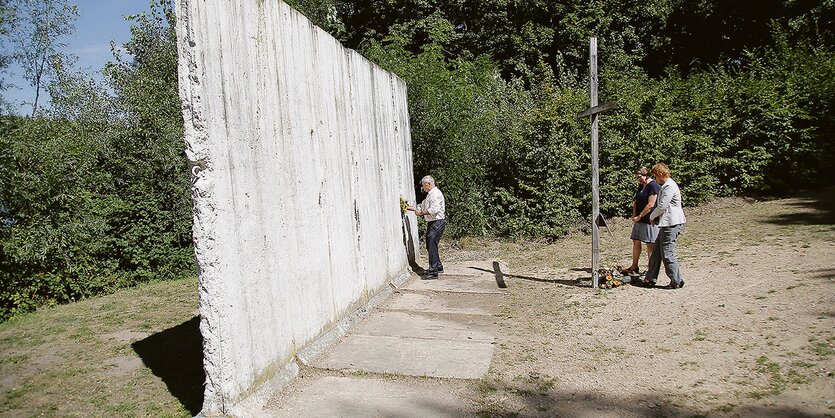 Leute an einer Mauer