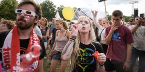 Menschen demonstrieren bei unteilbar, eine Frau bläst Seifenblasen