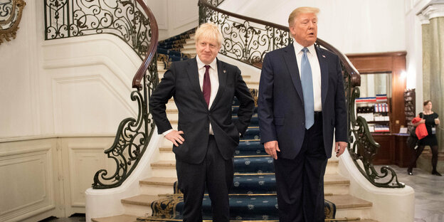 Boris Johnson und Donald Trump stehen nebeneinander auf einem Treppenabsatz
