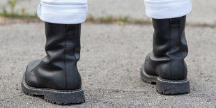 Schwarze Springerstiefel und weiße Hose