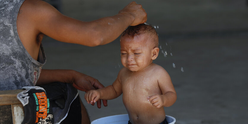 Ein Baby wird in einer Unterkunft für Migranten gebadet