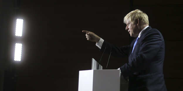 Boris Johnson ist im Profil zu sehen und zeigt nach vorn
