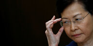 Hongkongs Regierungschefin Carrie Lam rückt ihre Brille zurecht und blickt sehr streng drein