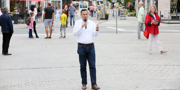 Mann mit weißem Hemd einsam in Fußgängerzone. Es ist Martin Dulig