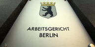 Auf dem Bild ist das Schild des Arbeitsgerichts Berlin zu sehen mit dem Berliner Wappen