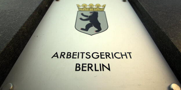 Auf dem Bild ist das Schild des Arbeitsgerichts Berlin zu sehen mit dem Berliner Wappen
