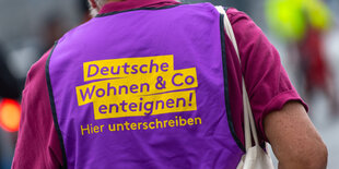 Mann mit Weste und Aufschrift "Deutsche Wohnen enteignen"