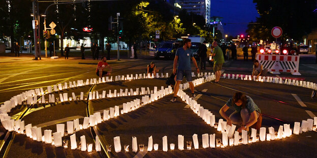 Demonstranten legen ein Peace-Zeichen aus Kerzen
