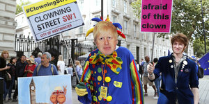Ein Demonstrant mit einer Maske des britischen Premierministers Johnson protestiert im Clownskostüm vor dem Haus 10 Downing Street