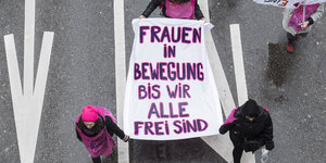 Frauen tragen ein Transparent mit der Aufschrift "Frauen in Bewegung bis wir alle frei sind"