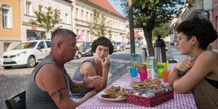 Drei Menschen im Gespräch an einem Tisch in Angermünde