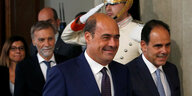NBicola Zingaretti verlässt lachend den Palast des Präsidenten. Er wird begleitet von Parteikollegen. Im Hintergrund steht ein Soldat und salutiert.