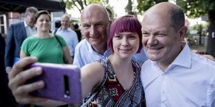 Dietmar Woidke (SPD), Ministerpräsident von Brandenburg, und Olaf Scholz (SPD), Bundesfinanzminister, nehmen bei der Wahlkampf-Abschlussveranstaltung der SPD Brandenburg beim Wassersportclub Möwe Oranienburg mit einer Besucherin ein Selfie auf