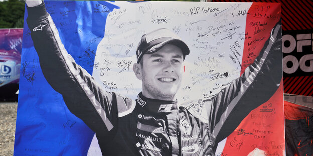 Ein Trauerbild des Rennfahrers auf einem Hintergrund mit französischer Flagge
