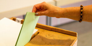 Eine Frau wirft ihren Stimmzettel zur Landtagswahl in die Wahlurne