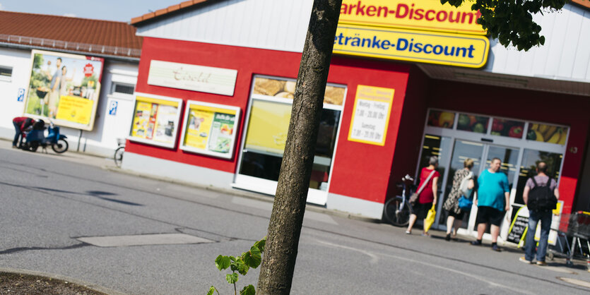 Ein schräg fotografierter Netto-Supermarkt, im Vordergund ein Baum