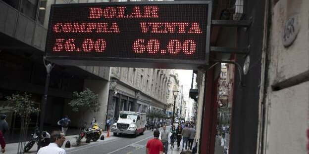 Leute kommen an einer Wechselstube in Buenos Aires vorbei. Die argentinische Regierung will die Milliardenkredite des Internationalen Währungsfonds (IWF) später zurückzahlen als bislang vorgesehen.