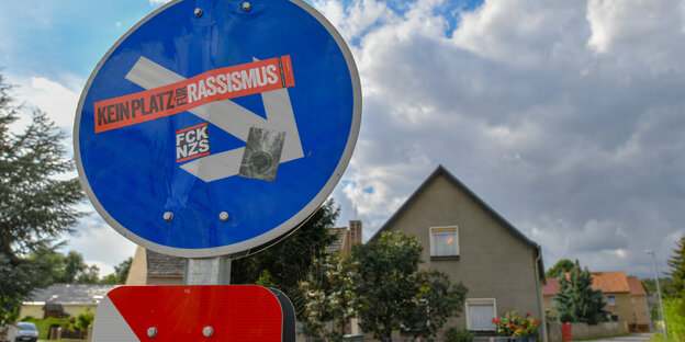 "Kein Platz für Rassismus", steht auf einem Aufkleber auf einem Straßenschild im brandenburgischen Hirschfeld
