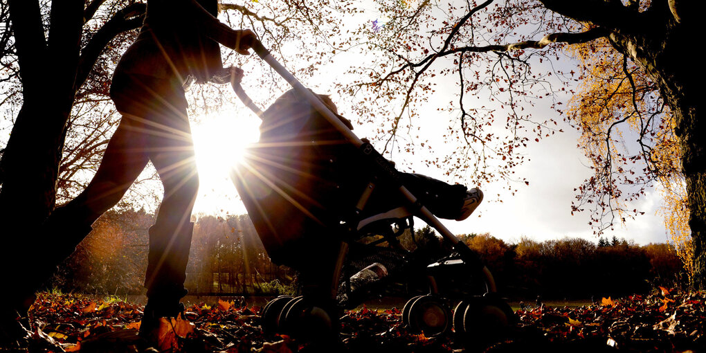 Frau schiebt Kinderwagen