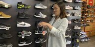 Jennifer Lee, deren Familie die das Footprint Schuhgeschäft in San Francisco besitzt, steht an einer Wand mit Sportschuhen, von denen viele in China hergestellt werden und ab dem 1. September neuen US-Zöllen auf chinesische Waren unterliegen werden.