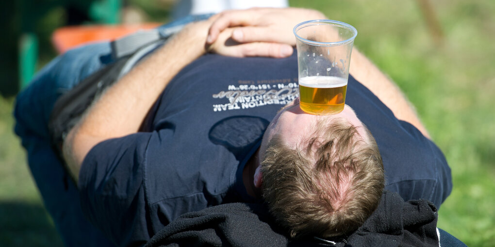 Mann mit Bierglas auf der Stirn