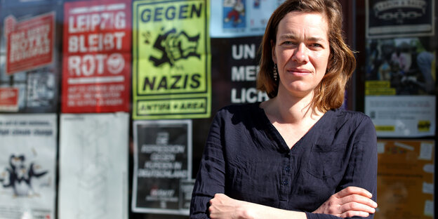 Juliane Nagel steht mit verschränkten Armen vor ihrem Abgeordnetenbüro in Leipzig