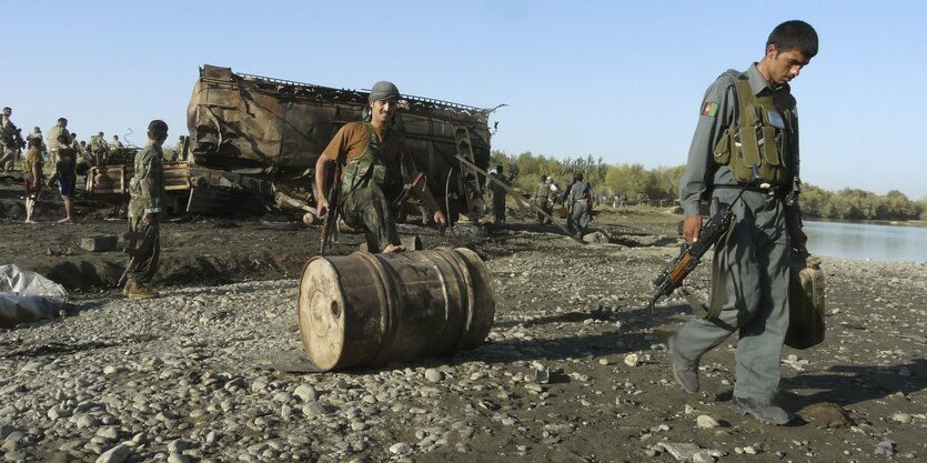 Afghanische Soldaten rollen am 5. September 2009 vor einem explodierten Tanklaster in Kundus eine Tonne.