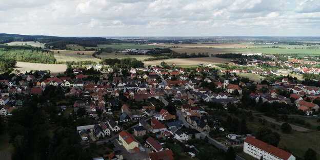 Luftaufnahme einer kleinstadt, di in Teilen im Schatten einer Wolke liegt