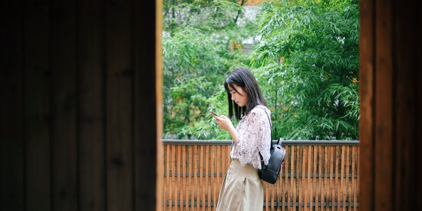 eine Frau hält ein Smartphone in ihren Händen