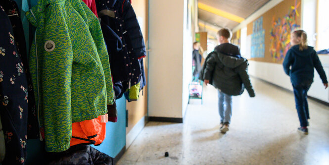 Kinder laufen durch den Flur einer Schule