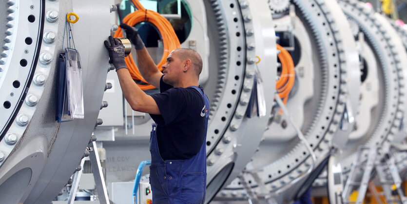 Ein Monteur arbeitet an Naben für Windkraftanlagen in einem Rostocker Werk